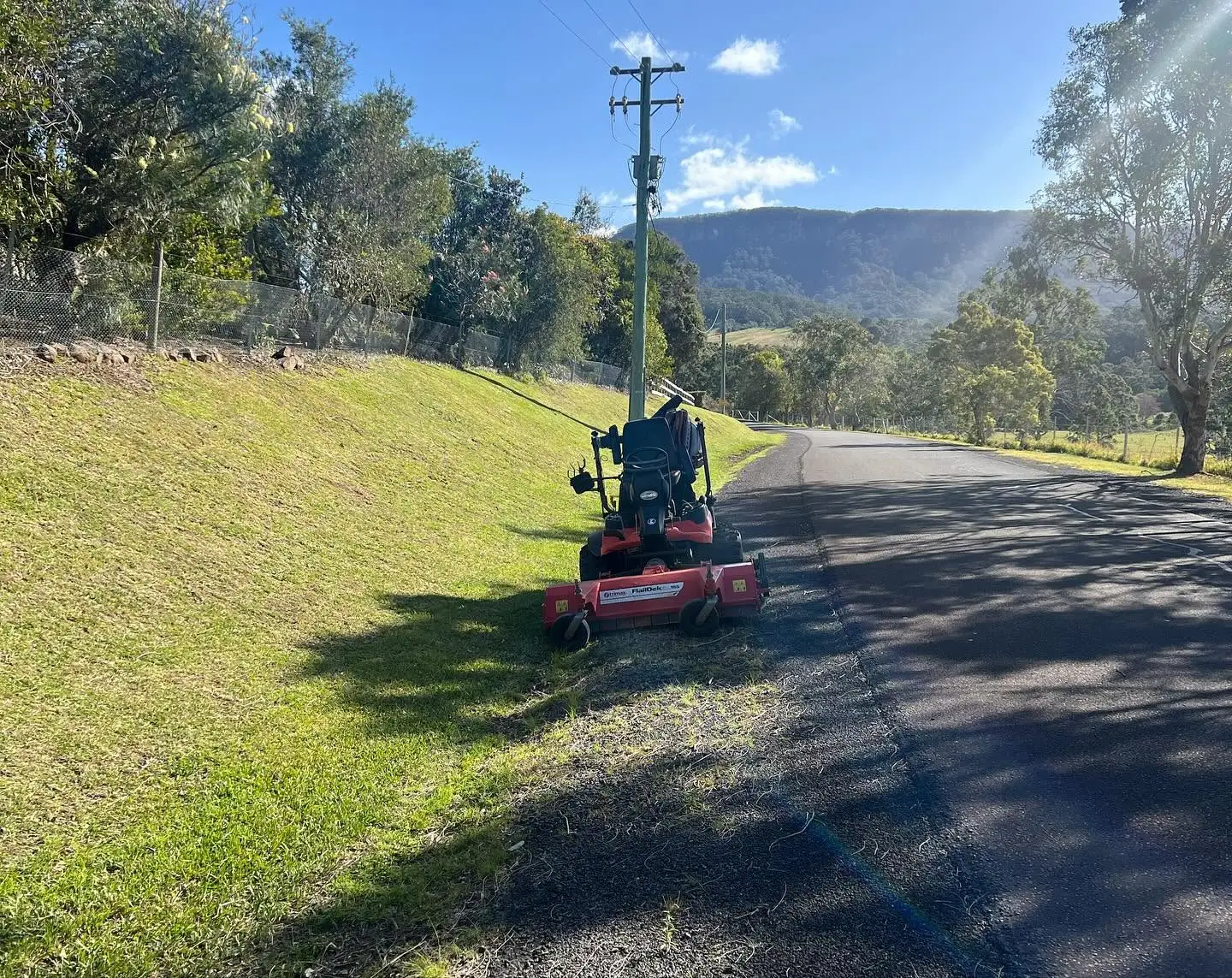 Commercial mower maintaining a roadside verge and reserve in the Illawarra